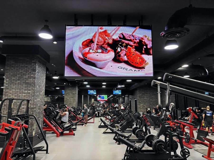 A food ad on a giant screen above the training floor of a men's gym in Sabah Al Salem, Kuwait